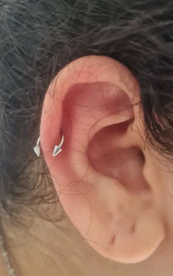 Piercing de hélix com joia de seta na orelha